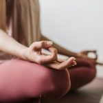 Close-up of a woman meditating indoors, practicing yoga for wellness and relaxation.